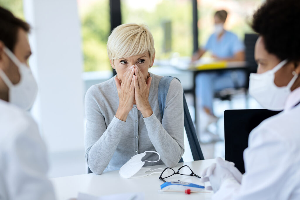 Mature woman feeling worried while having appointment at doctor’